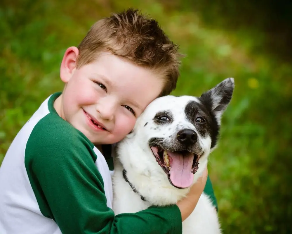 Boy hugging his puppy.