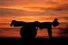 woman doing a pushup with her legs on an exercise ball