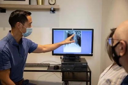 A doctor pointing to a spine 