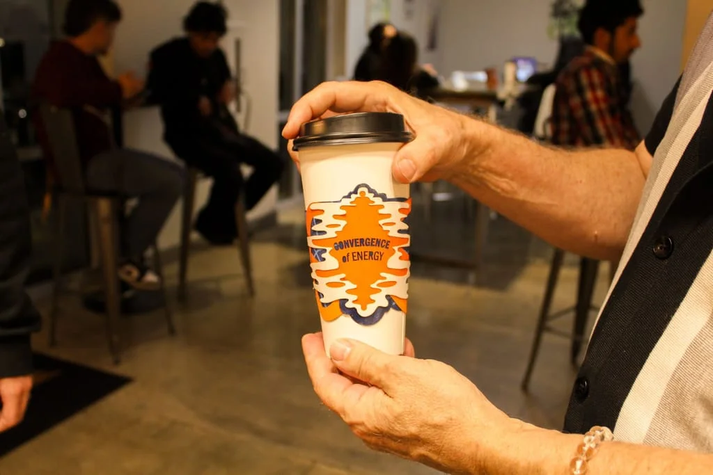 a man holding a drink with a custom designed drink sleeve