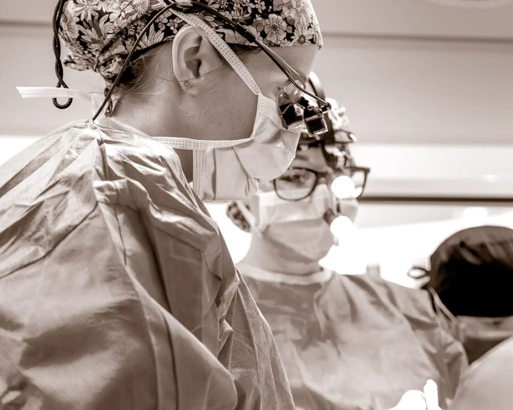 Plastic Surgeon doctors in the operating room performing an adam's apple reduction surgery.