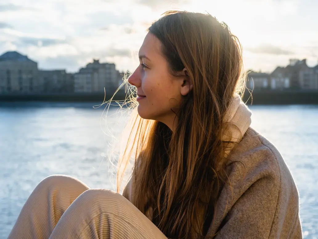 woman sitting by water