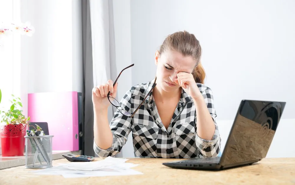 Woman having trouble looking at computer screen