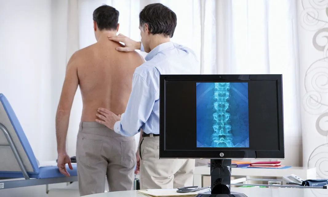 doctor assessing man spine