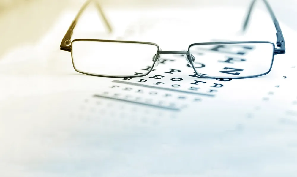 Eyeglasses on top of an eye chart