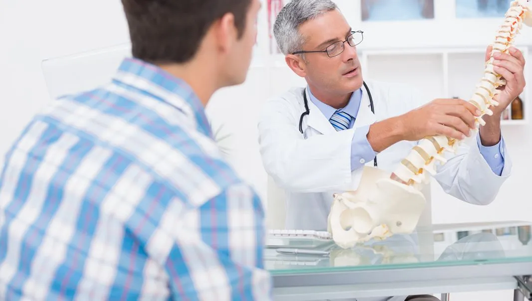 doctor showing spine model to a patient