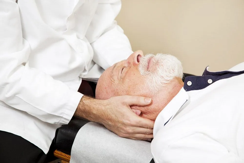 Old man having neck adjustment