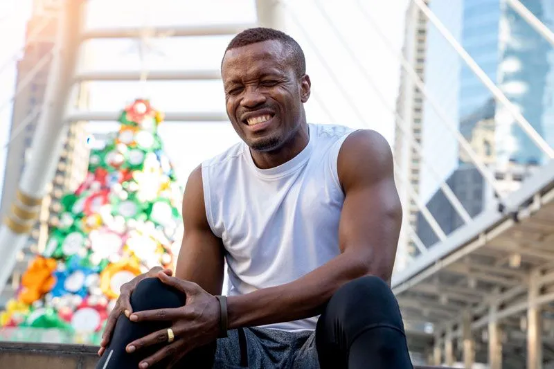 man holding his sore knee