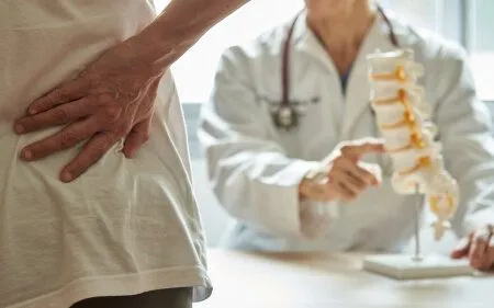 doctor showing spine model to a patient