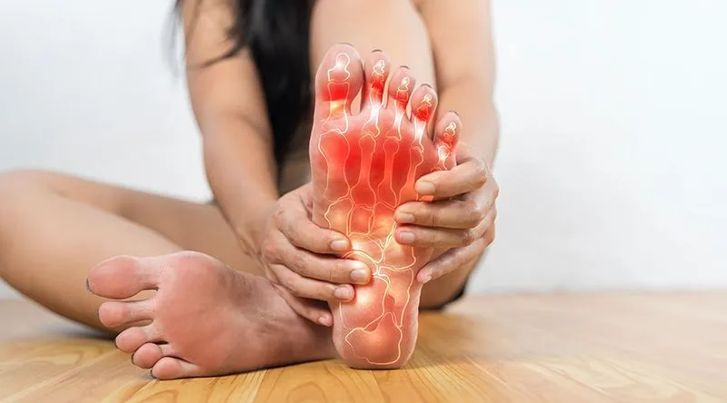 Person holding their sore foot