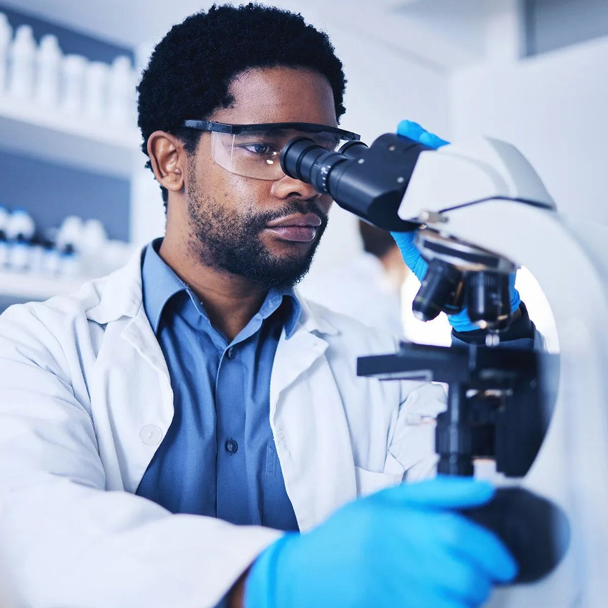 Technician viewing microscope