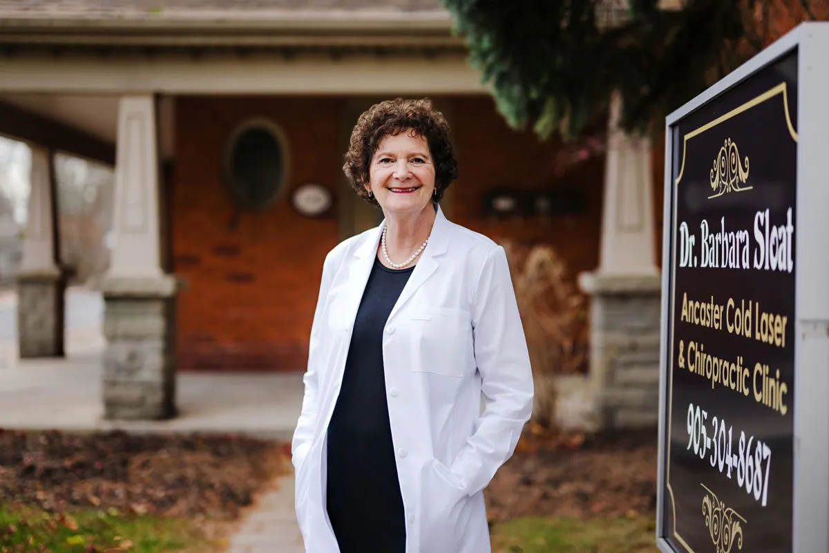 Dr. Sloat standing next to office sign