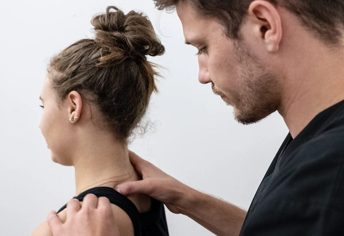 chiropractor checking the cervical spine of female patient suffering from neck pain
