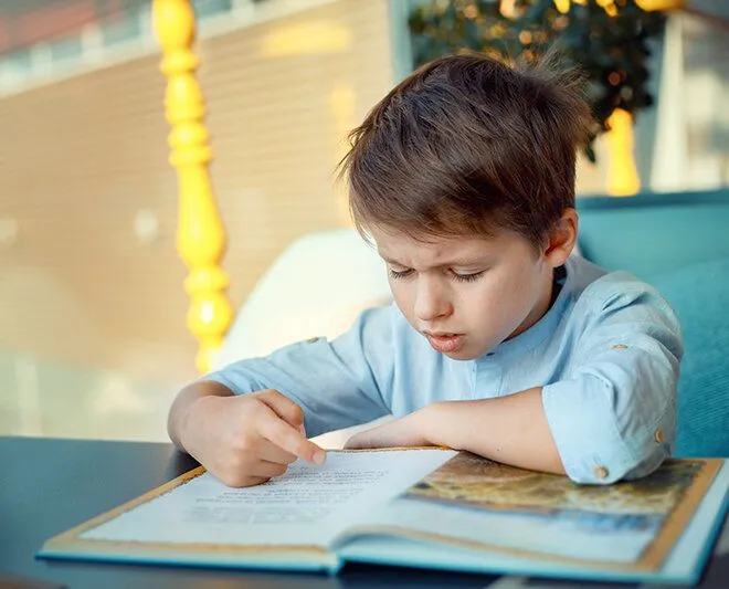 Young boy trying to read