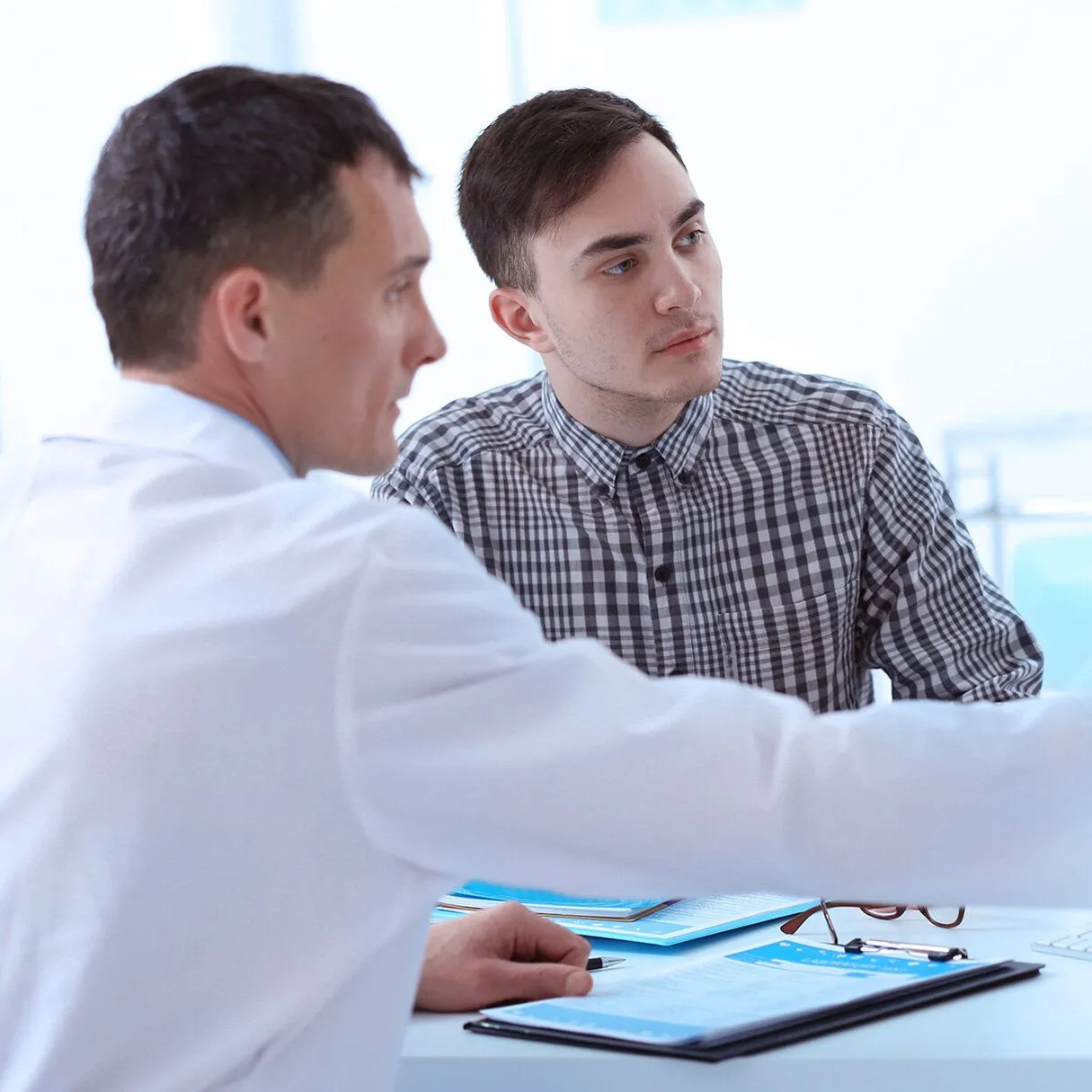 Doctor showing man results on a computer screen