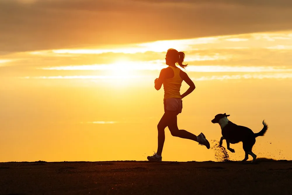 Woman running with her dog in summer.