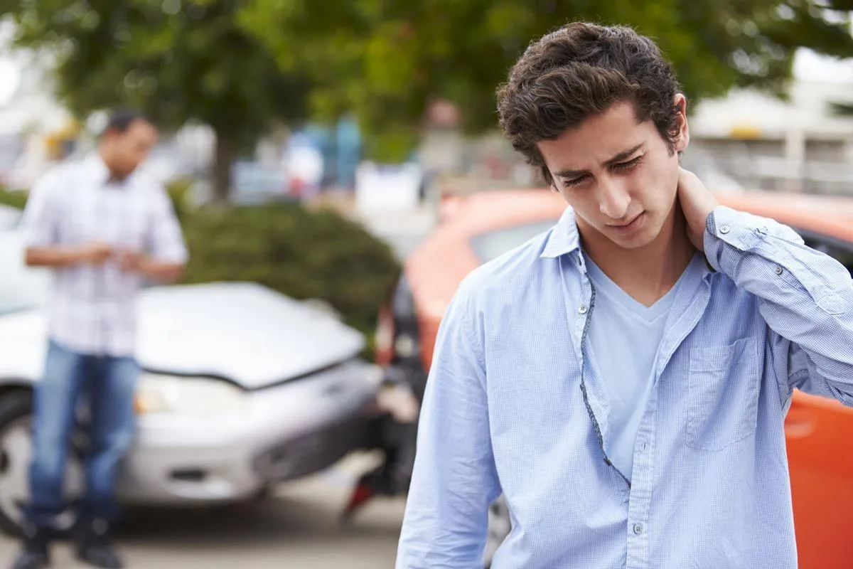 man holding his neck after accident