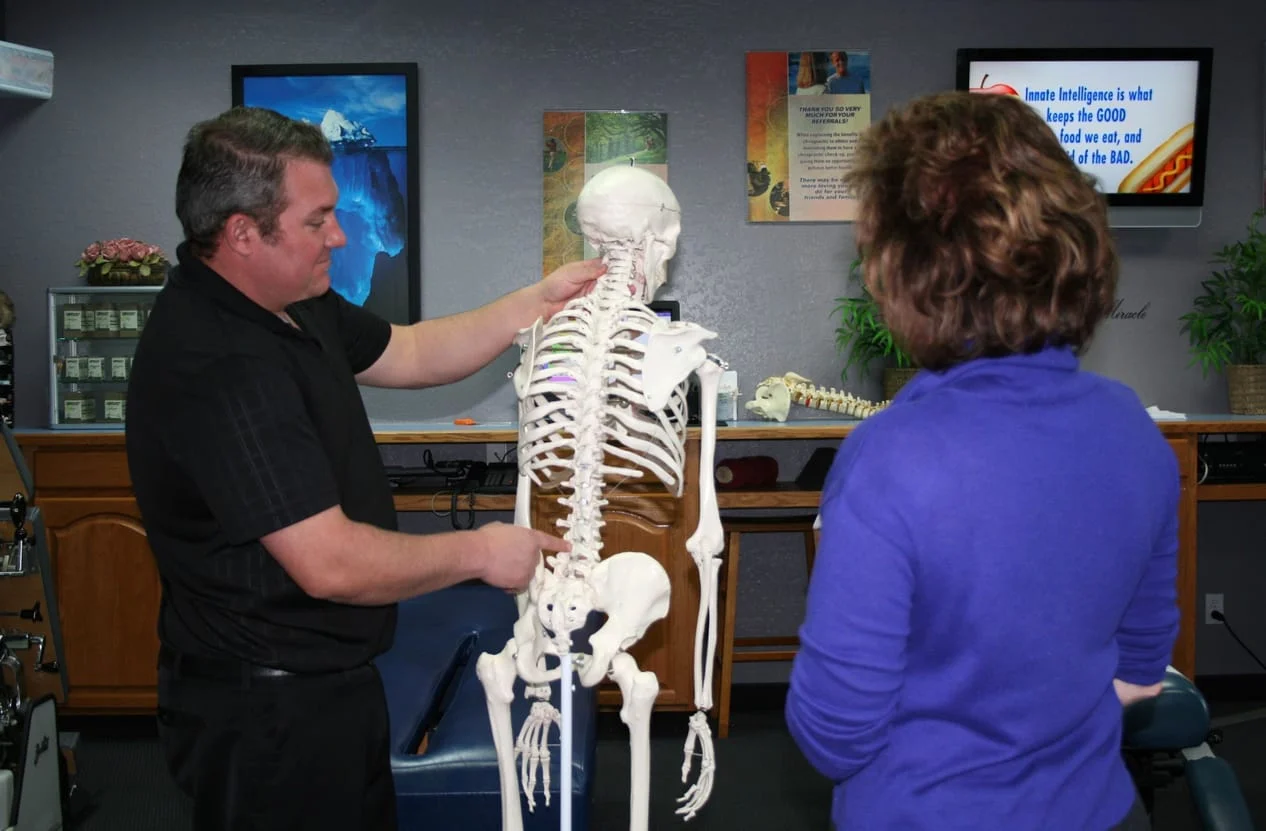 Doctor showing a patient the spine and how it relates to health and wellness