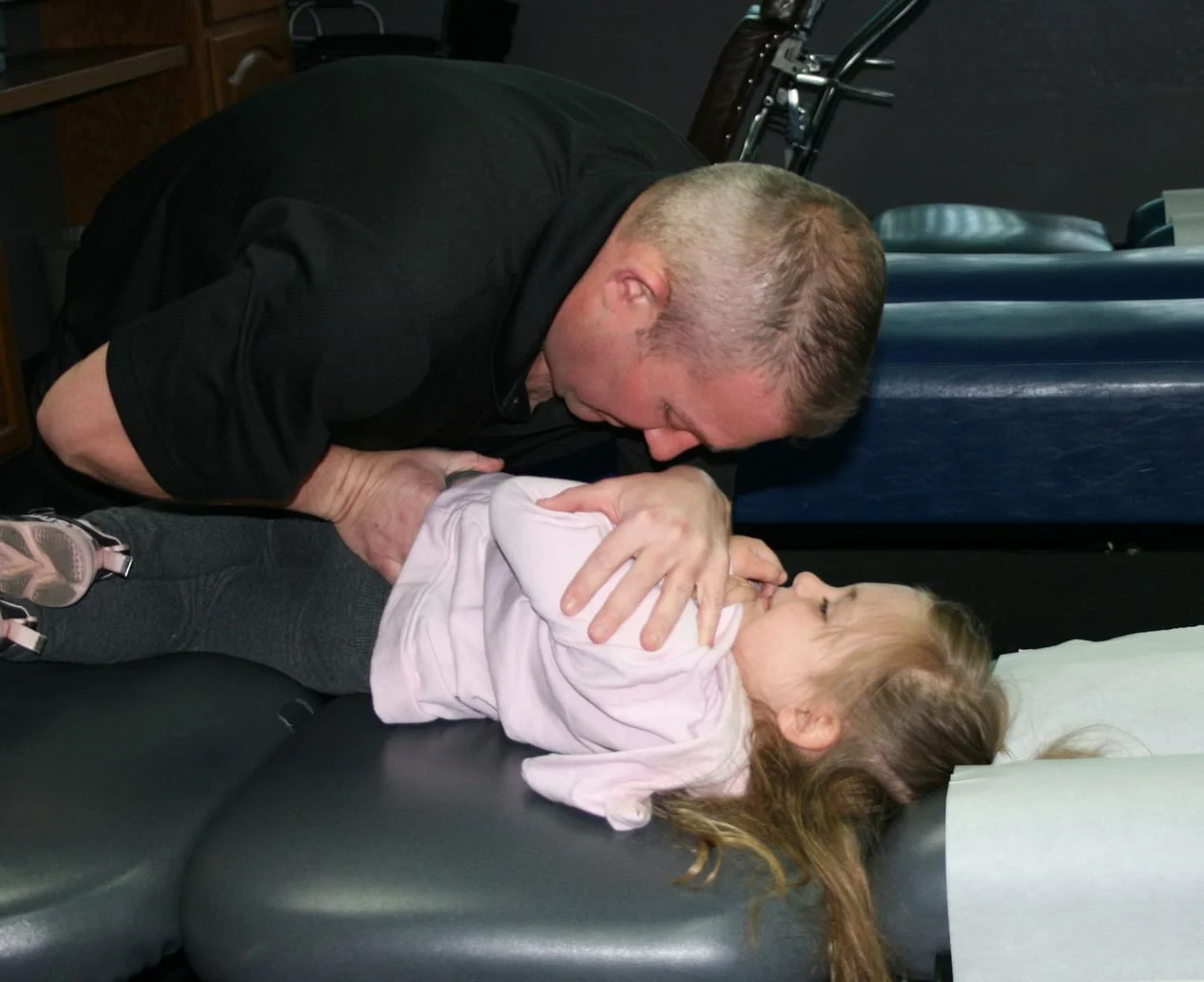 Doctor giving a small child a chiropractic Adjustment