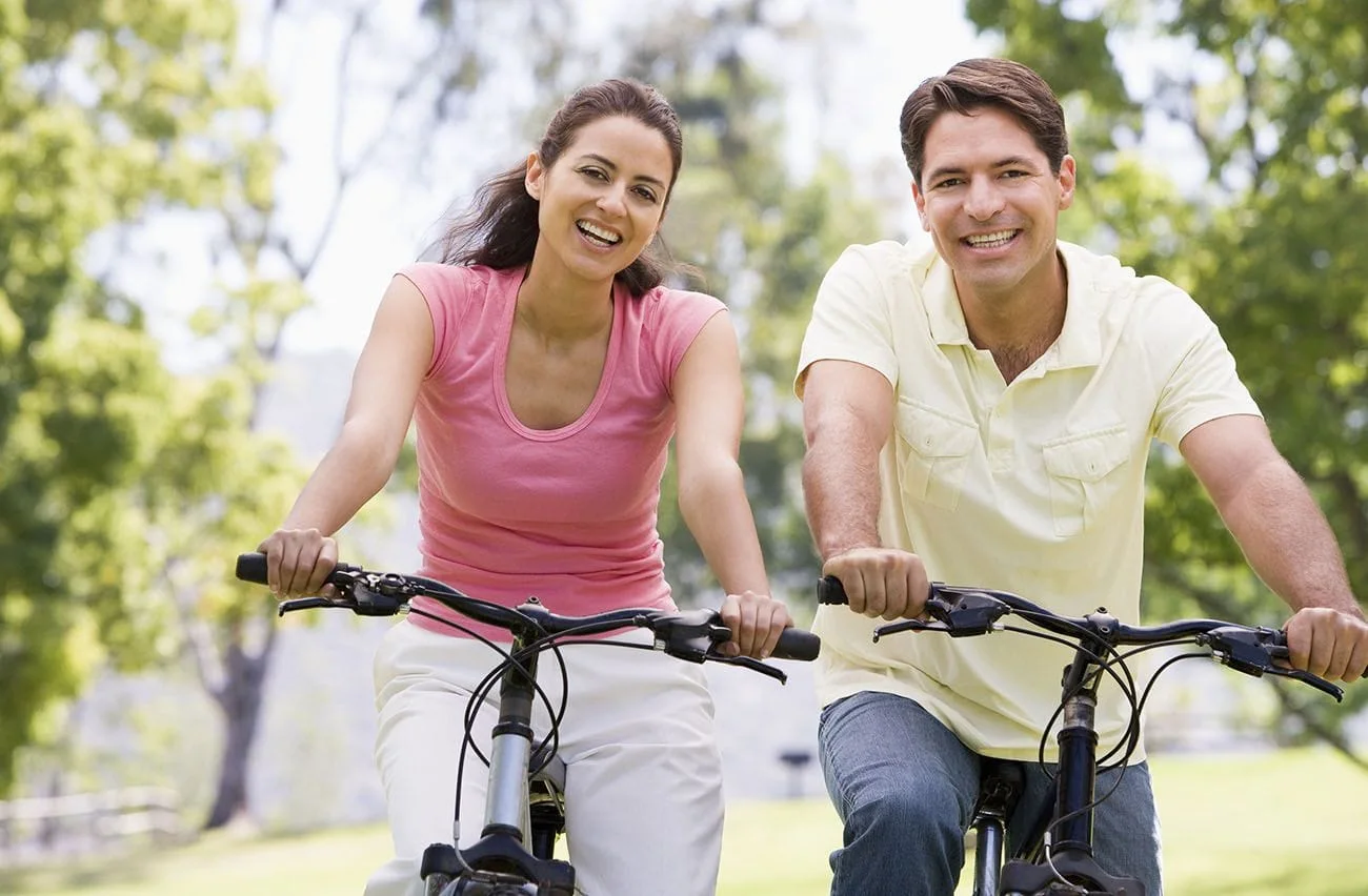 Happy healthy couple riding bikes