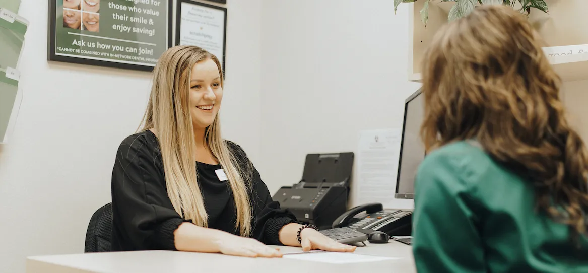 Office Coordinator, Macie Blythe assisting a patient in the Crockett Dental Care office.