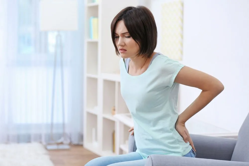 Young lady holding her lower back