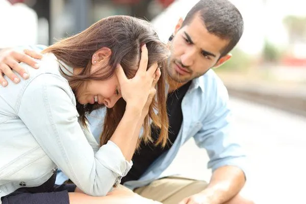 Woman having a panic attack with man nearby