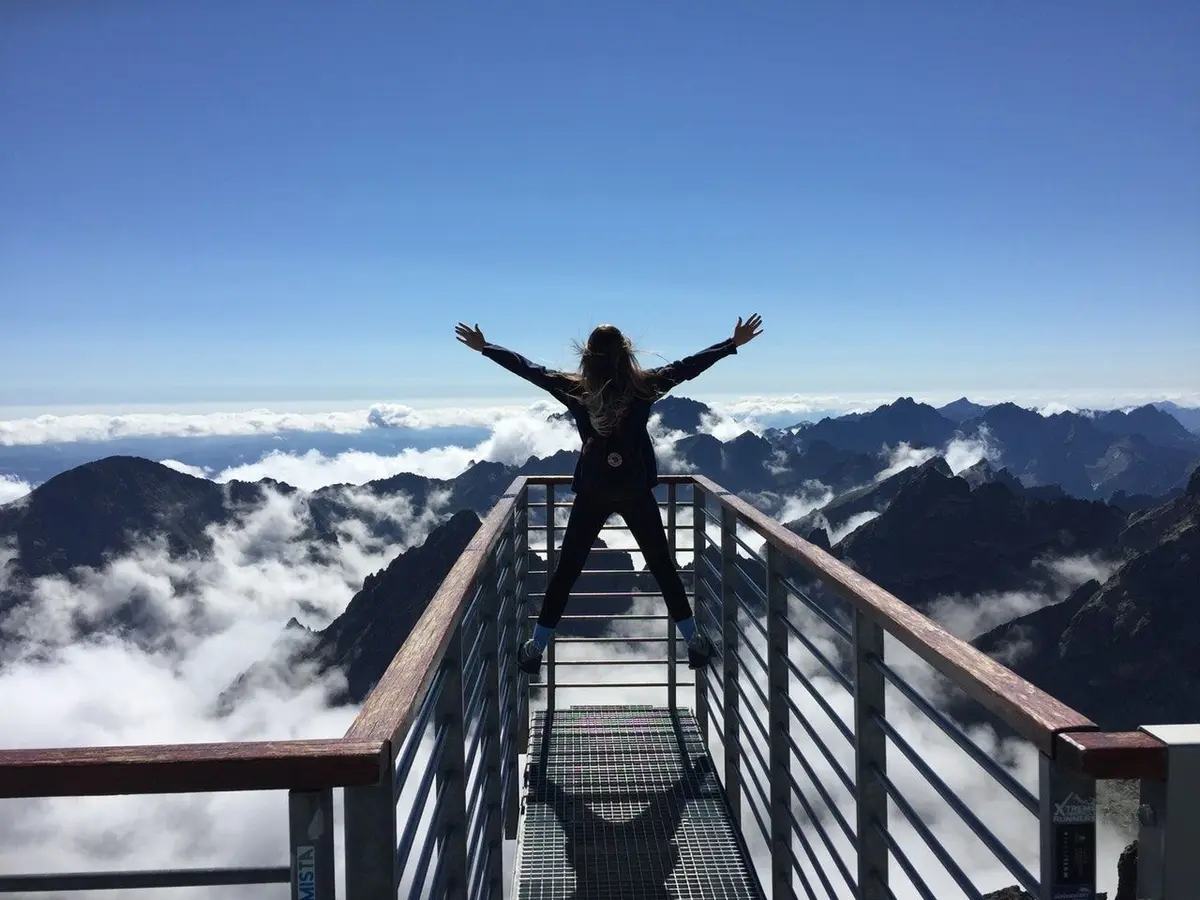 girl arms out looking at mountains