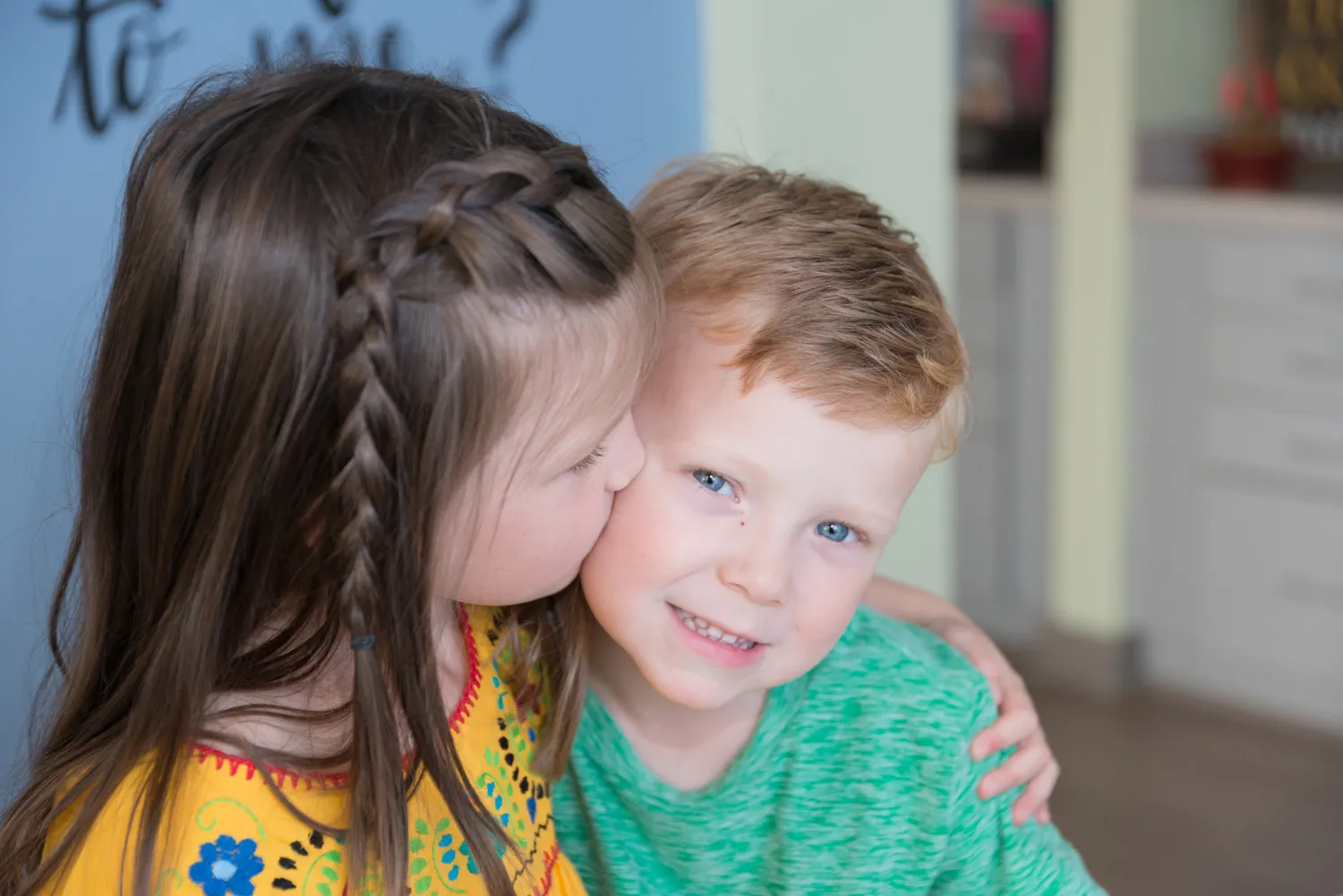 sister kissing brother