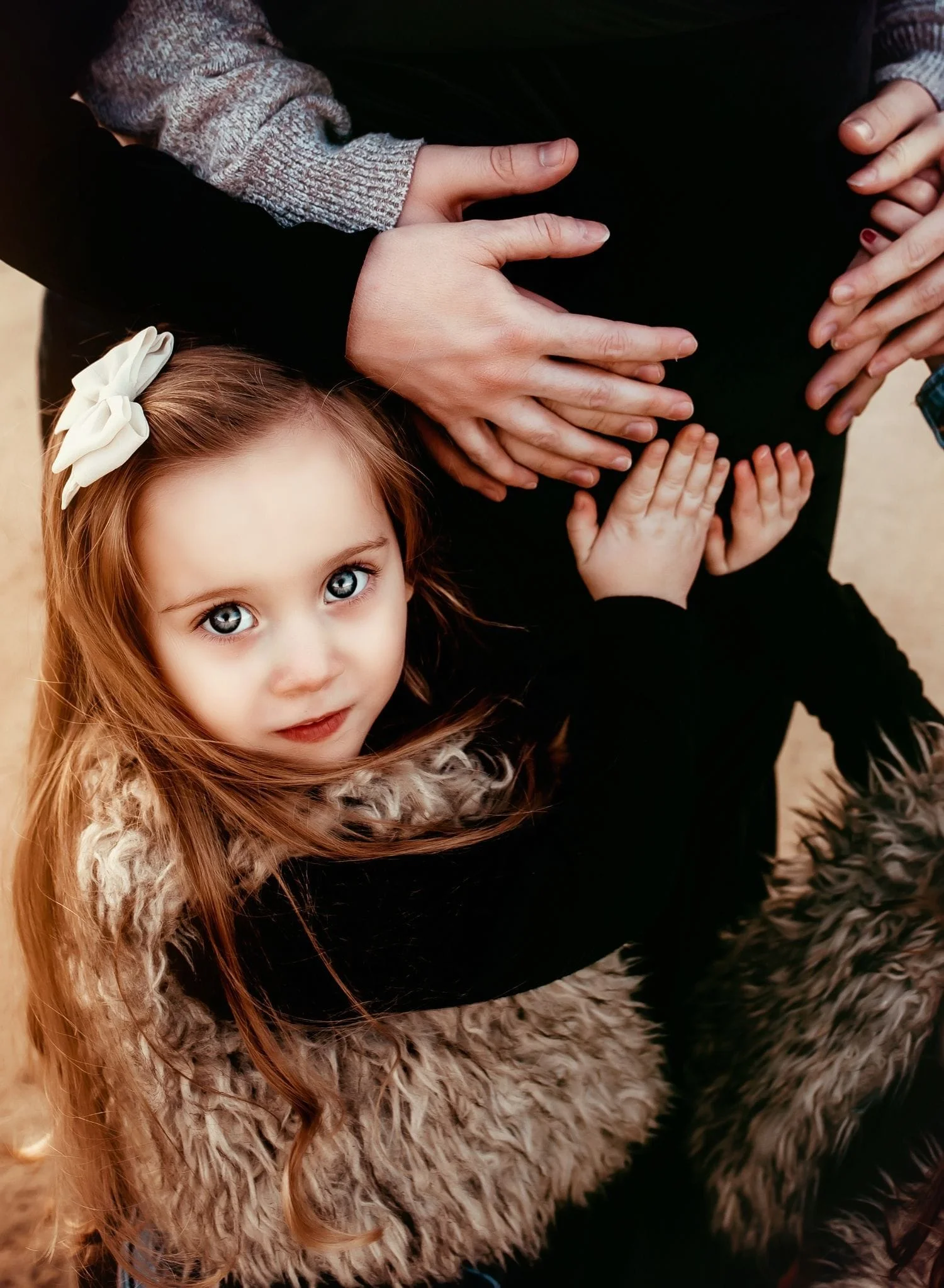 baby girl touching mom's baby bump