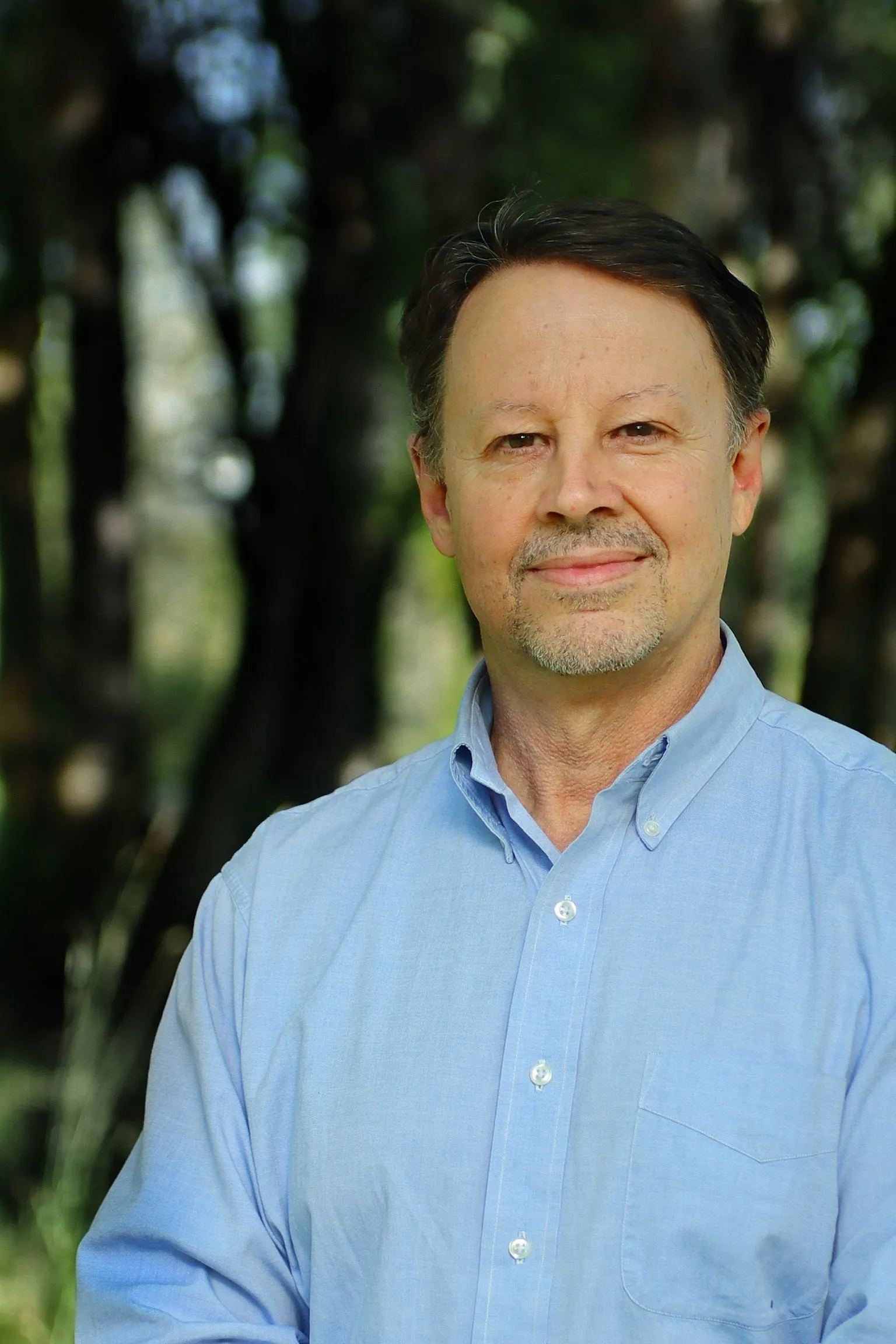 Dr. Fuegy standing in front of trees