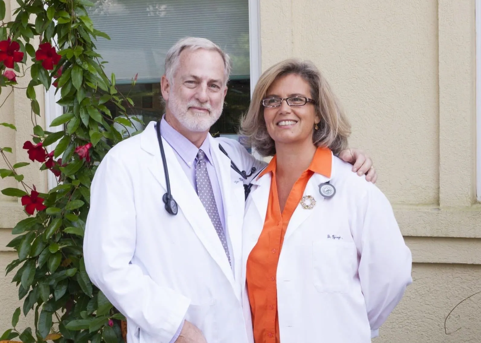 Dr. Baxter and Dr. G standing next to each other in white medical coats