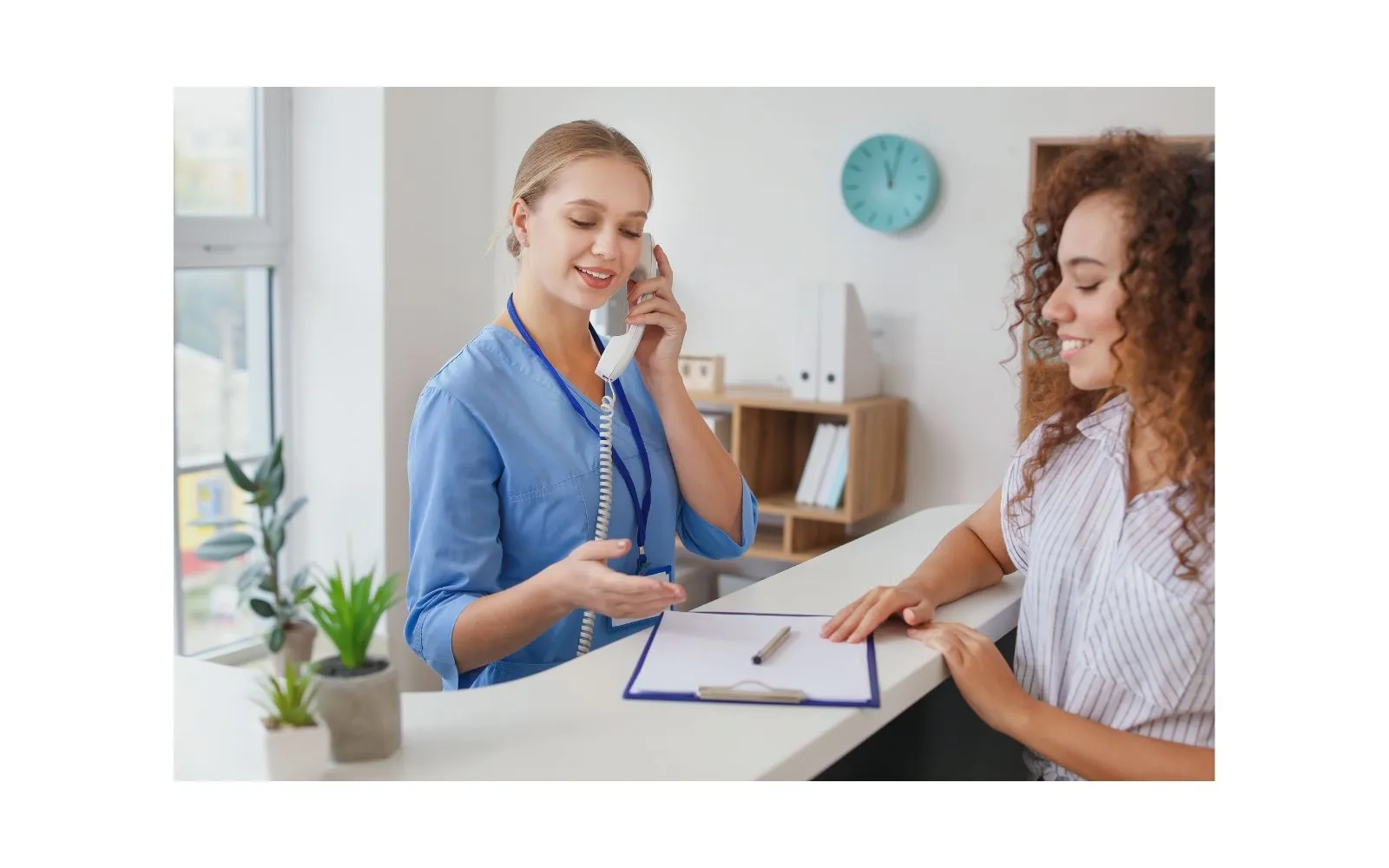 Friendly chiropractic clinic staff in Tulsa helping patient at front desk