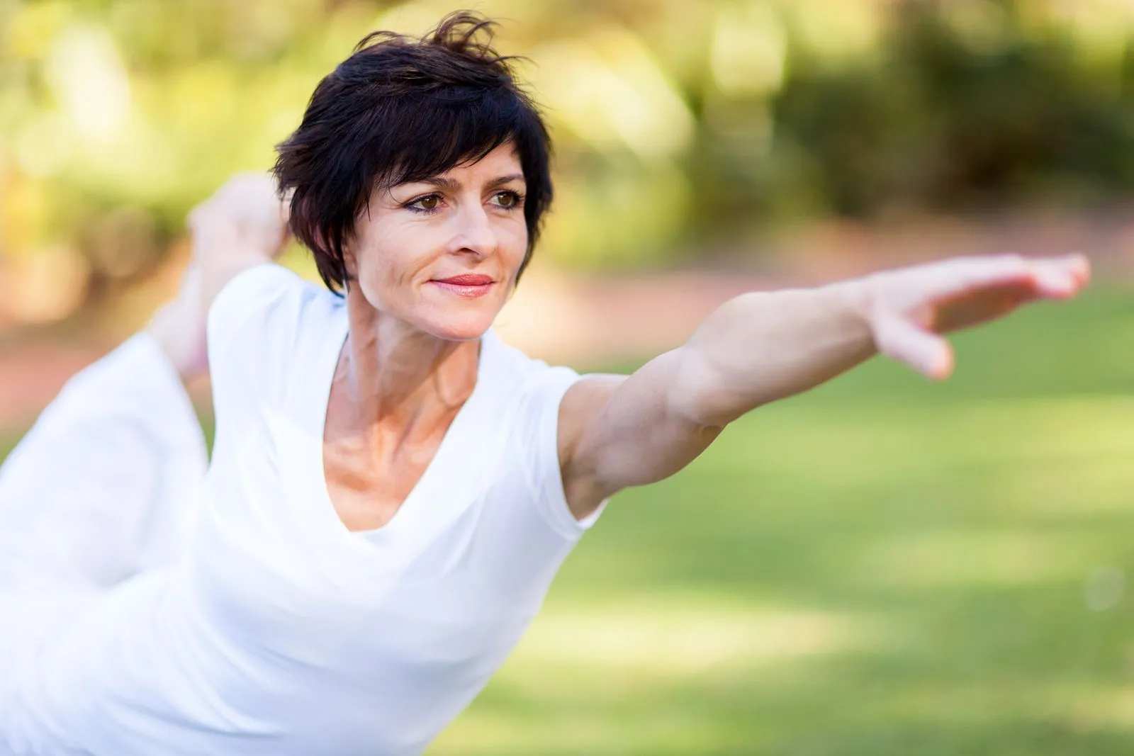 Woman dressed in white doing a warrior pose in Vinayam yoga-classes