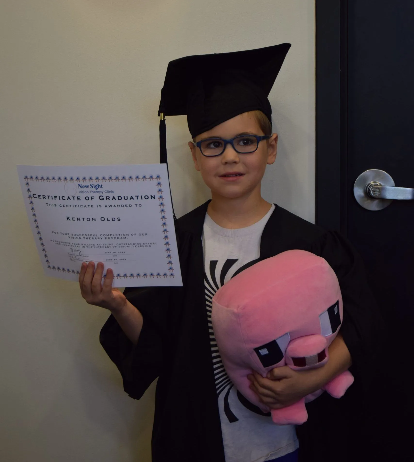 young boy holding a certificate of graduation