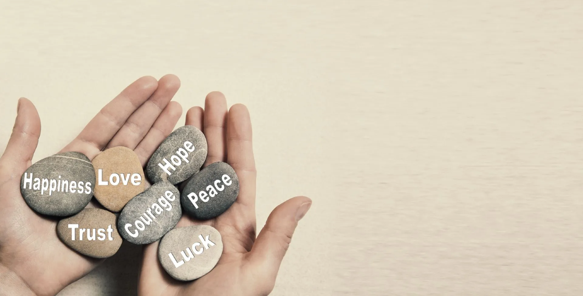 Hands holding small stones with encouraging words