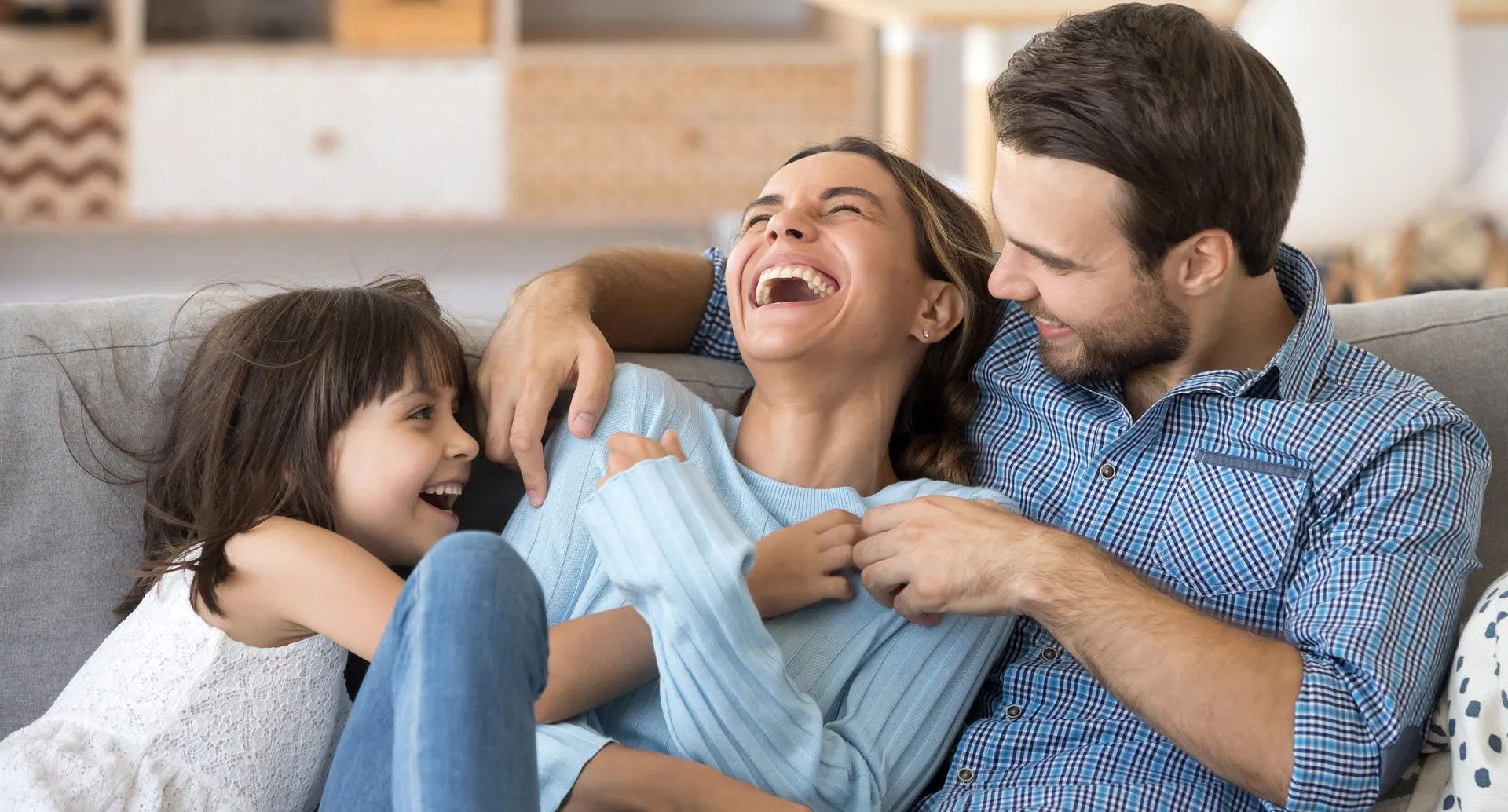 Happy family sitting on the couch and laughing