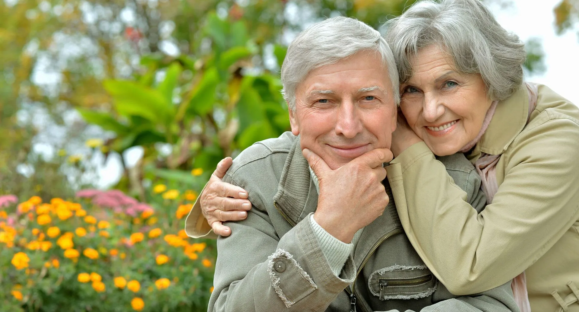 older couple outside beside some flowers