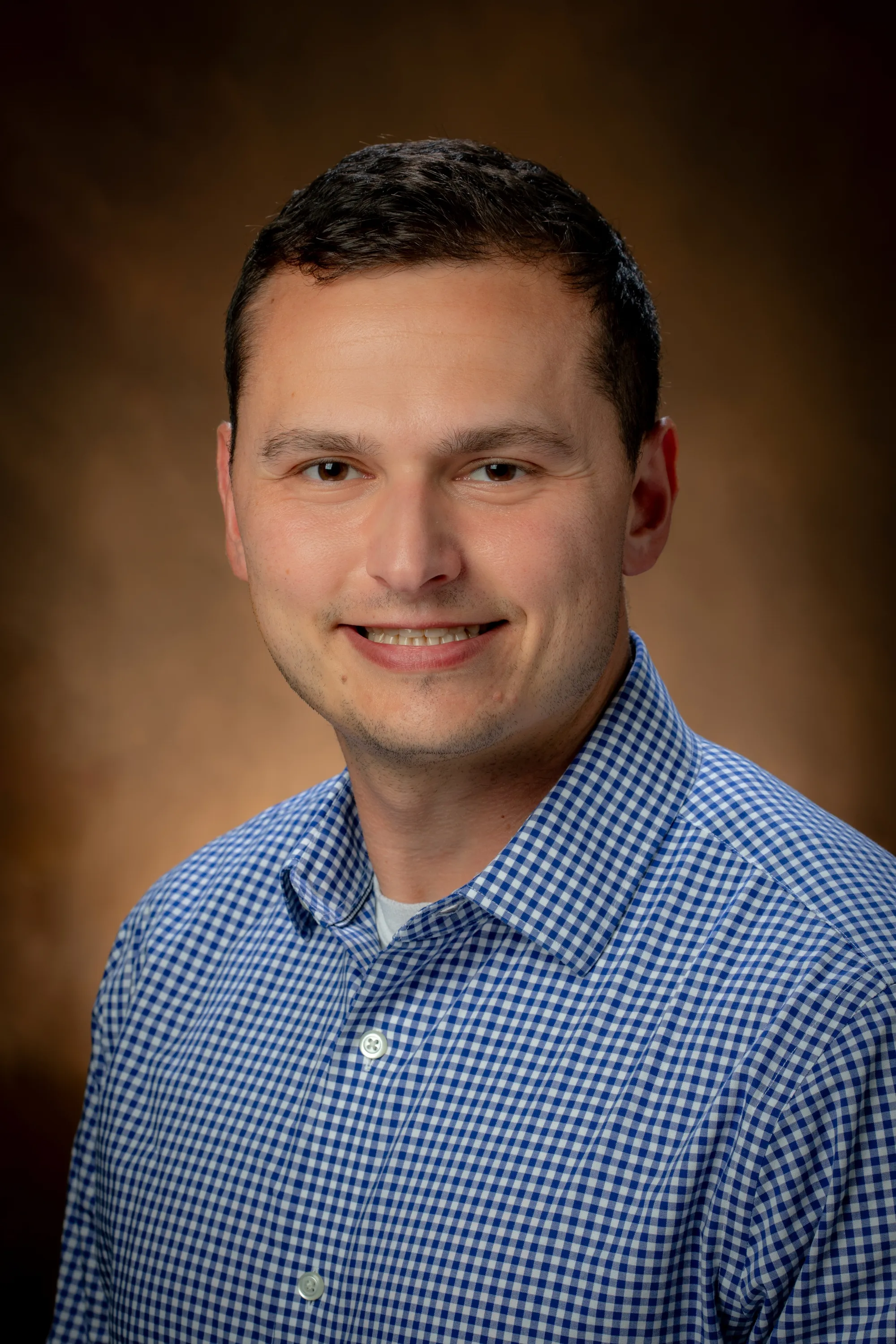 Justin Carbone in a blue shirt smiling at camera