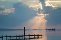 woman standing on a pier overlooking a lake