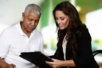 Young woman showing older man notebook