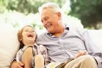 grandfather laughing with grandson in chair