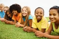 Smiling children laying on field