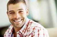 Man wearing a red plaid shirt smiling