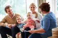 Family of four smilng with counselor