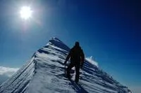 man at peak of snowy mountain
