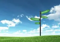 green field with a sign that points in several directions