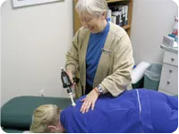 Photo of Dr. Flemming using a device to adjust a patient