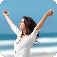 image of woman on the beach raising her arms