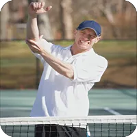 image of man at a tennis court holding his elbow